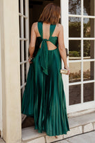 Back view of emerald halter maxi with criss-cross tie detail and zipper closure, demonstrating the adjustable fit and open-back styling.