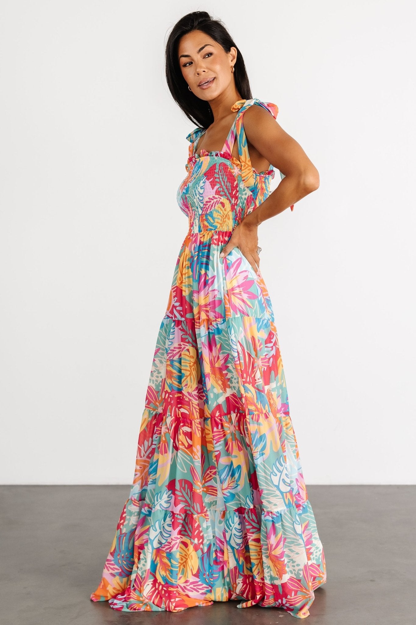 Back view of Santana maxi dress highlighting full skirt, gathered tiers, and smooth fully lined polyester fabric in tropical print.