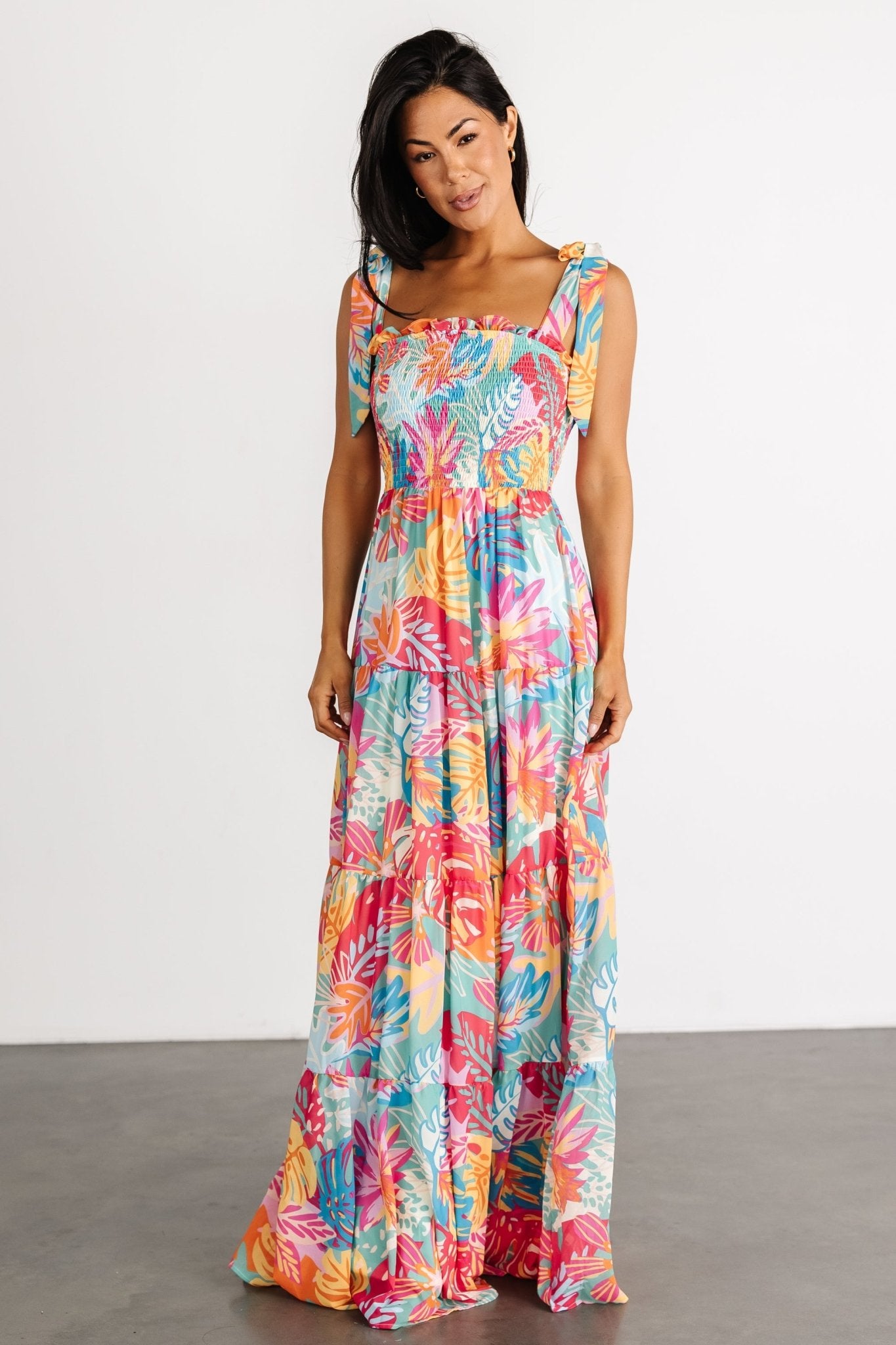 Close-up of smocked bodice and ruffle-trim square neckline showing texture and supportive stretch in the multi-print fabric.