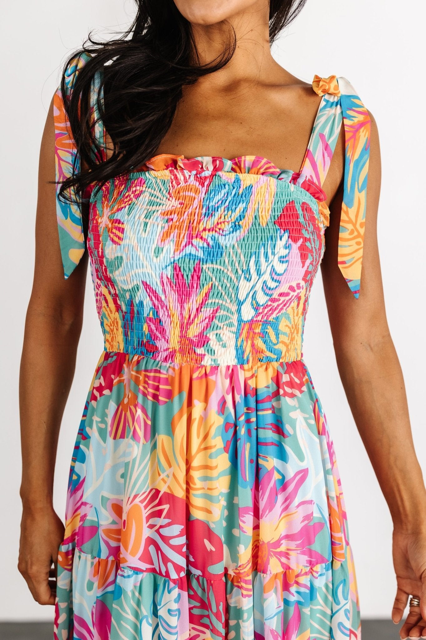 Side profile of Santana maxi dress showing tiered skirt movement and flowing silhouette in bright multi floral print on model.