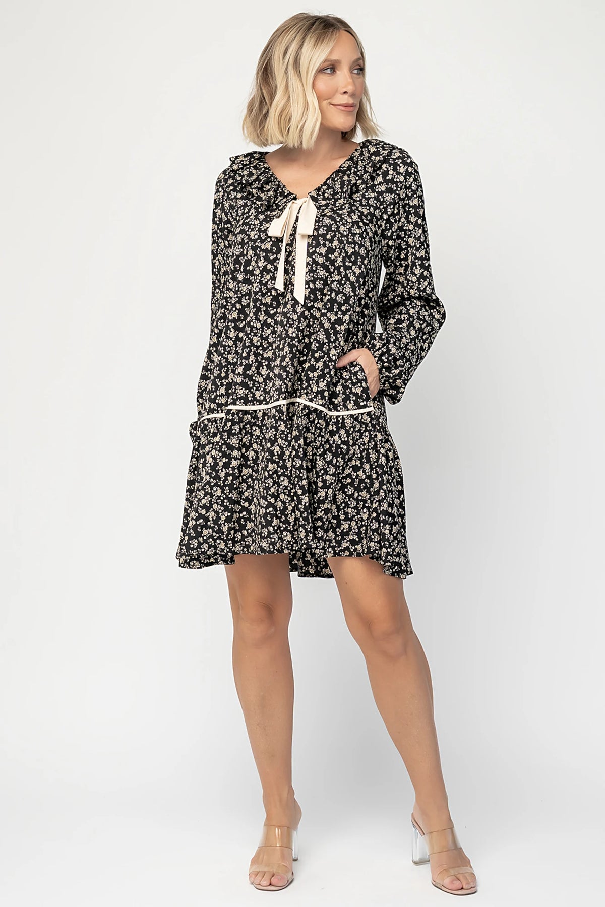 Shantel Bow Front Short Dress in Black Floral with ruffled neckline, faux bow front, long sleeves, and short skirt.