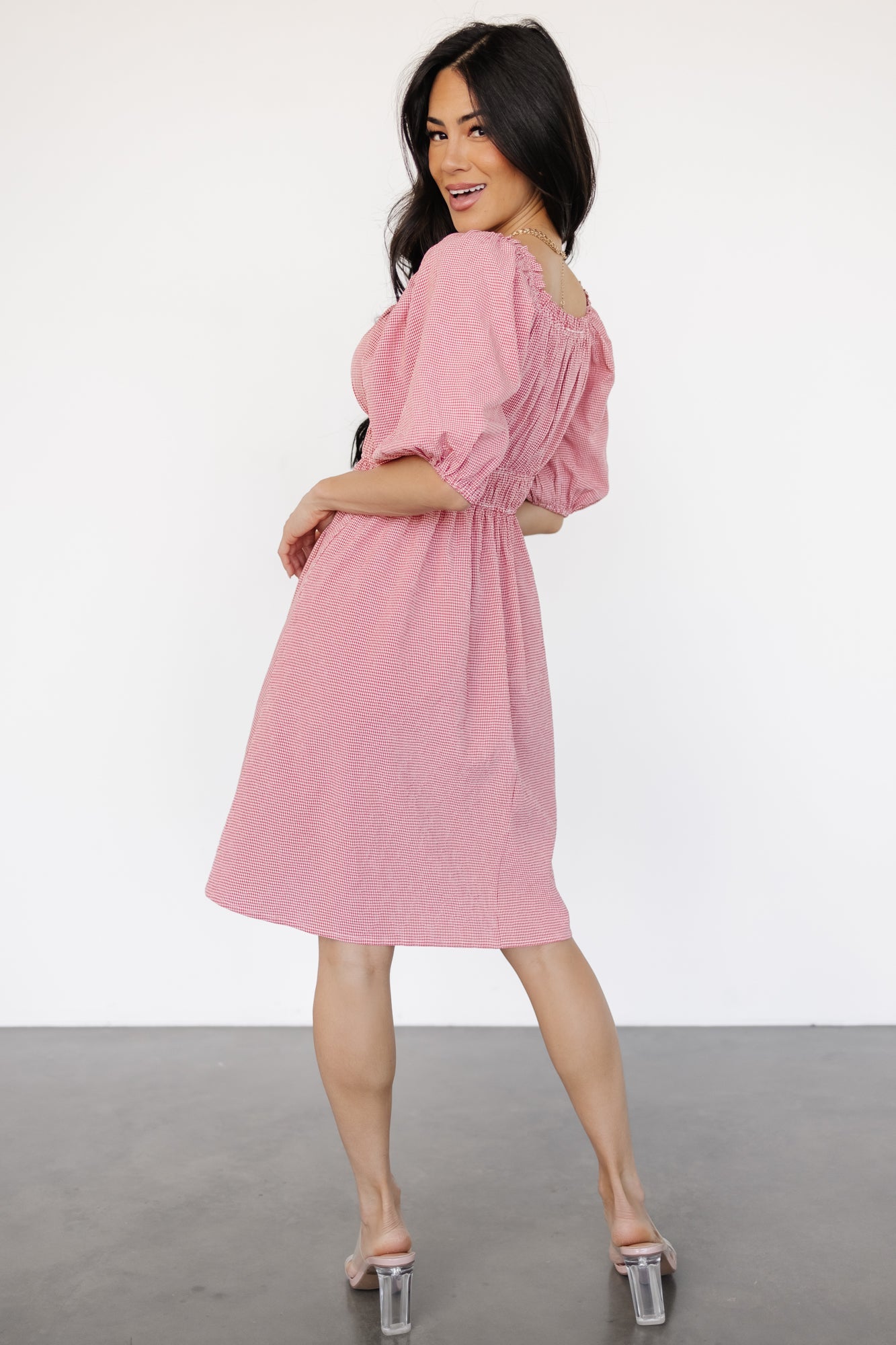 Side profile of the Shawna short dress emphasizing the concealed side pocket, double elastic waistband, feminine mini length, and textured gingham print.