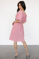 Side profile of the Shawna short dress emphasizing the concealed side pocket, double elastic waistband, feminine mini length, and textured gingham print.