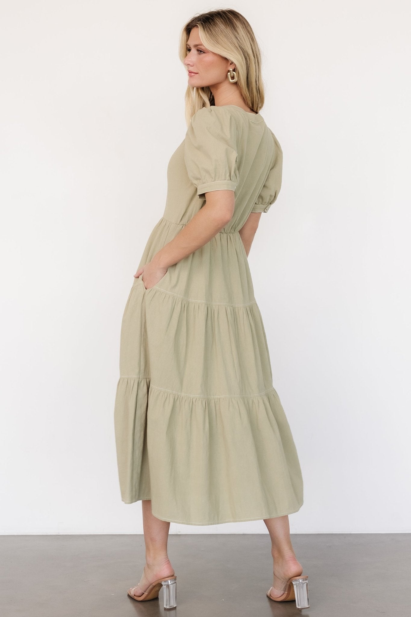 Detail shot of side pocket and skirt lining on a sage green tiered midi dress, showing functional design and coverage to last tier.