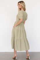 Detail shot of side pocket and skirt lining on a sage green tiered midi dress, showing functional design and coverage to last tier.