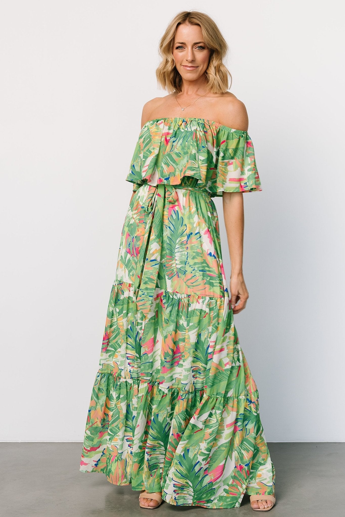 Styled flat-lay of Sonoma Off-Shoulder Maxi Dress in Green Multi, highlighting tropical print layout, removable belt, and full lining.