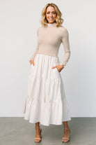 Model wearing Sophie Sweater Dress in Natural — three-tier maxi skirt and fully lined skirt shown in natural monochrome tones.