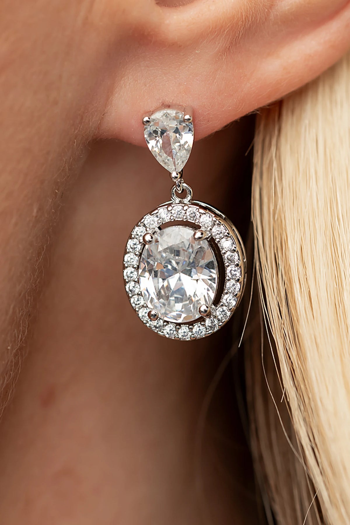 Stena Oval Dangle Drop Earrings in Silver with oval center stone and pavé stone border.