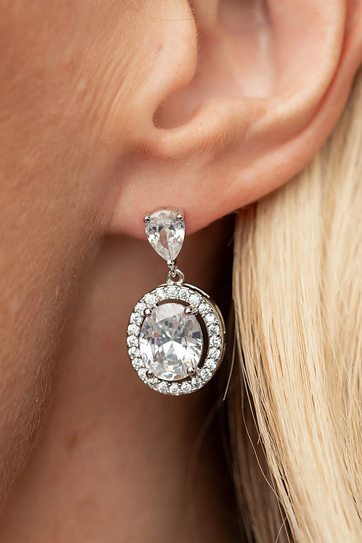 Stena Oval Dangle Drop Earrings in Silver with oval center stone and pavé stone border.