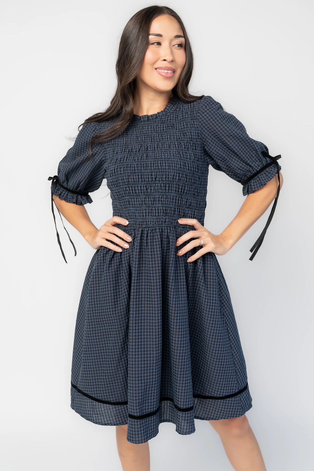 Susan Short Dress in Navy + Black Gingham with smocked bodice, elbow-length sleeves, black velvet ties, and velvet-trimmed hem.