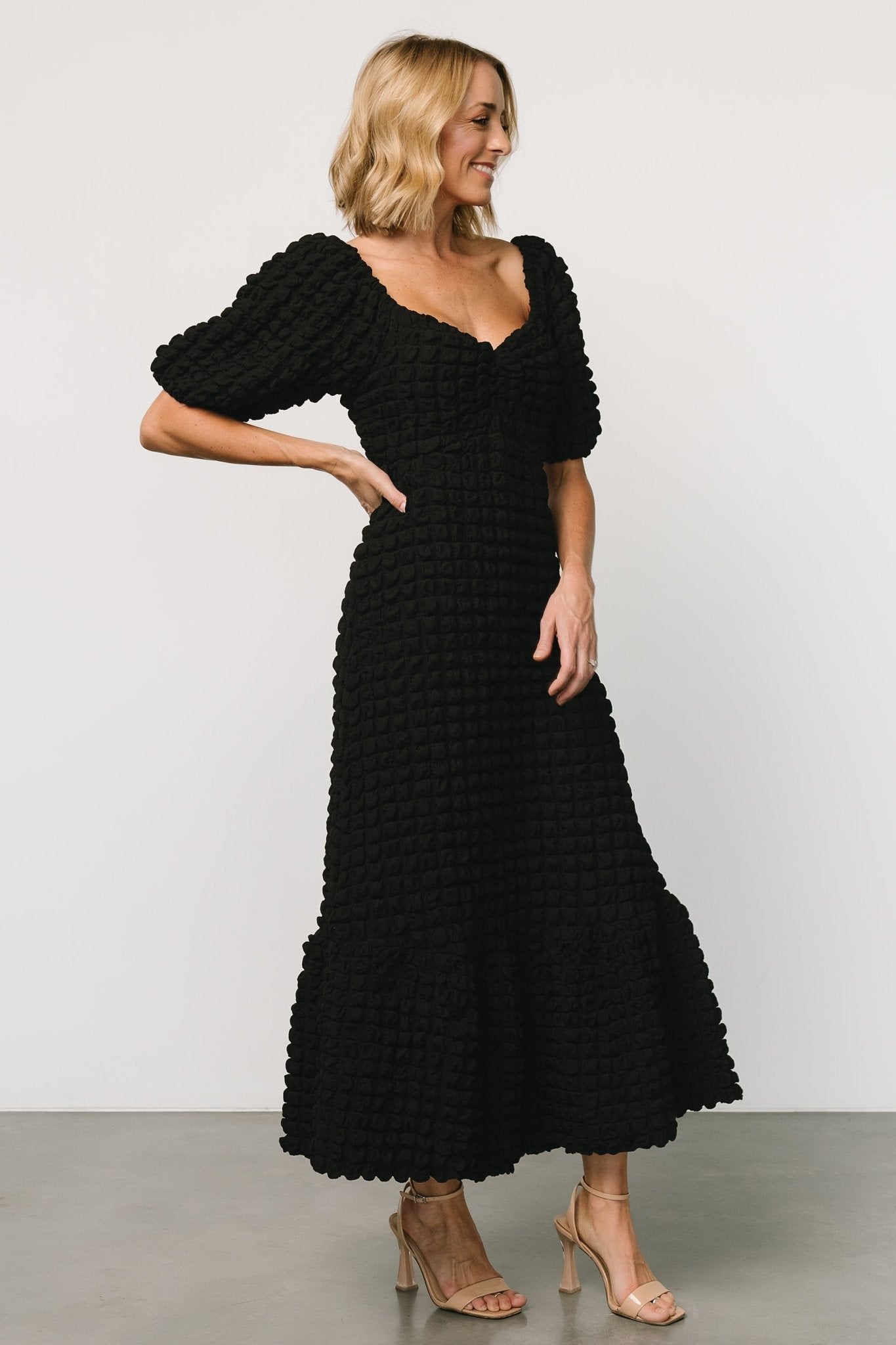 Front view of Therese textured midi dress in black featuring a sweetheart neckline and center-gathered bust for a feminine silhouette.
