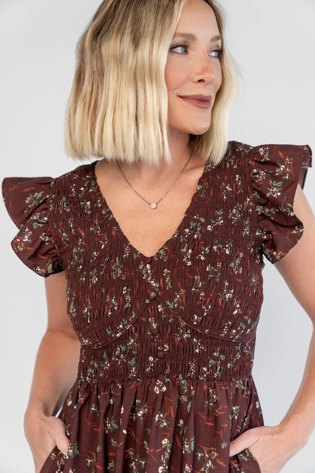 Tilly Smocked Dress in Dark Clove Floral with a V-neckline, flutter sleeves, and a smocked empire bodice.