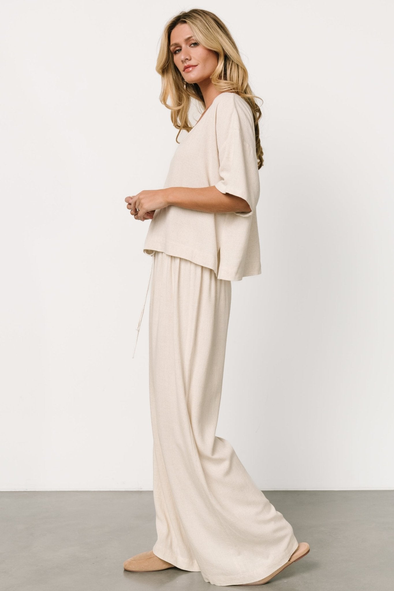 Detail shot of the pants' elastic waist and adjustable tie in the natural color on linen-blend fabric.