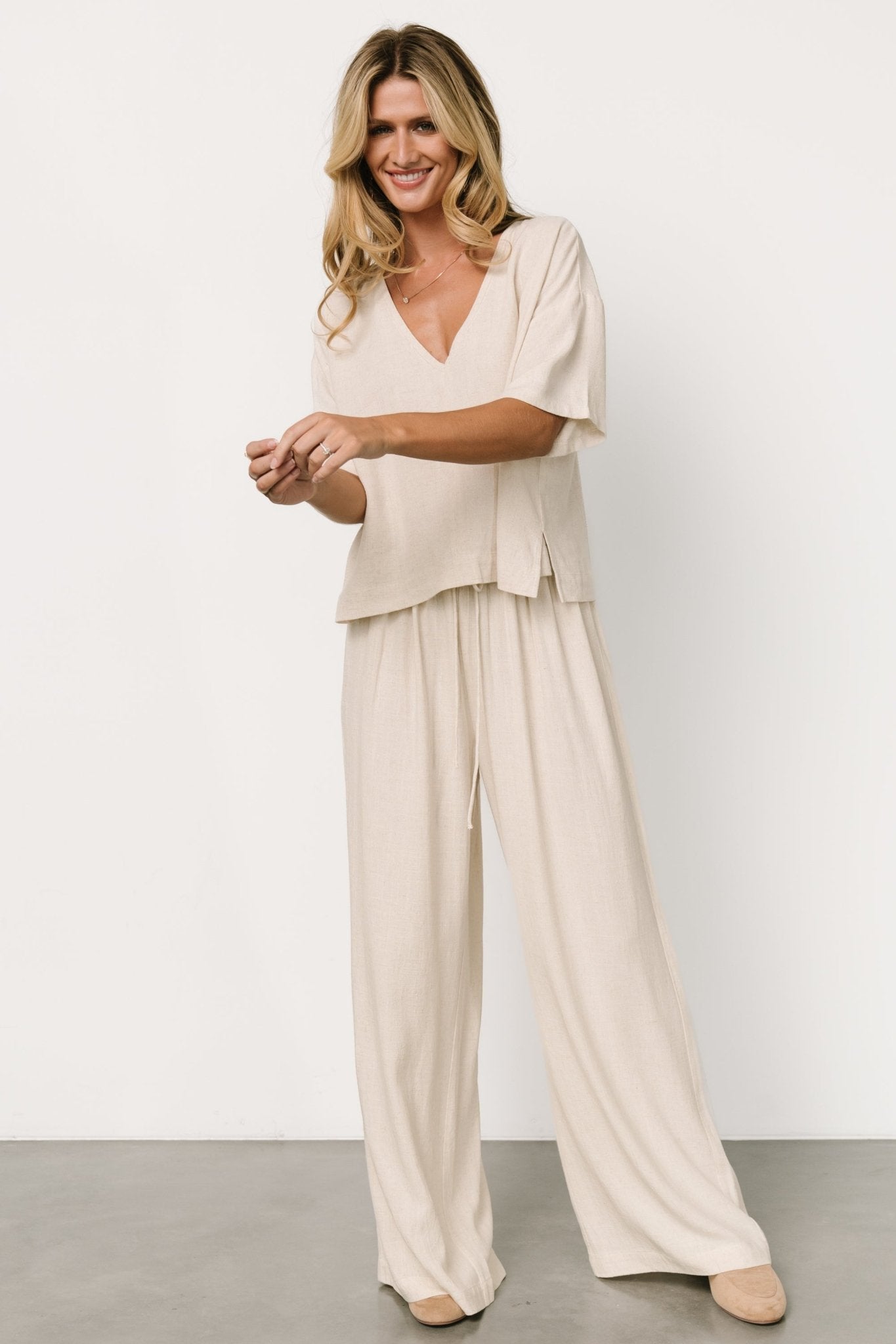 Styled outfit shot: natural linen-blend two-piece paired with sandals, illustrating versatile travel-to-evening styling options.