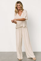 Styled outfit shot: natural linen-blend two-piece paired with sandals, illustrating versatile travel-to-evening styling options.