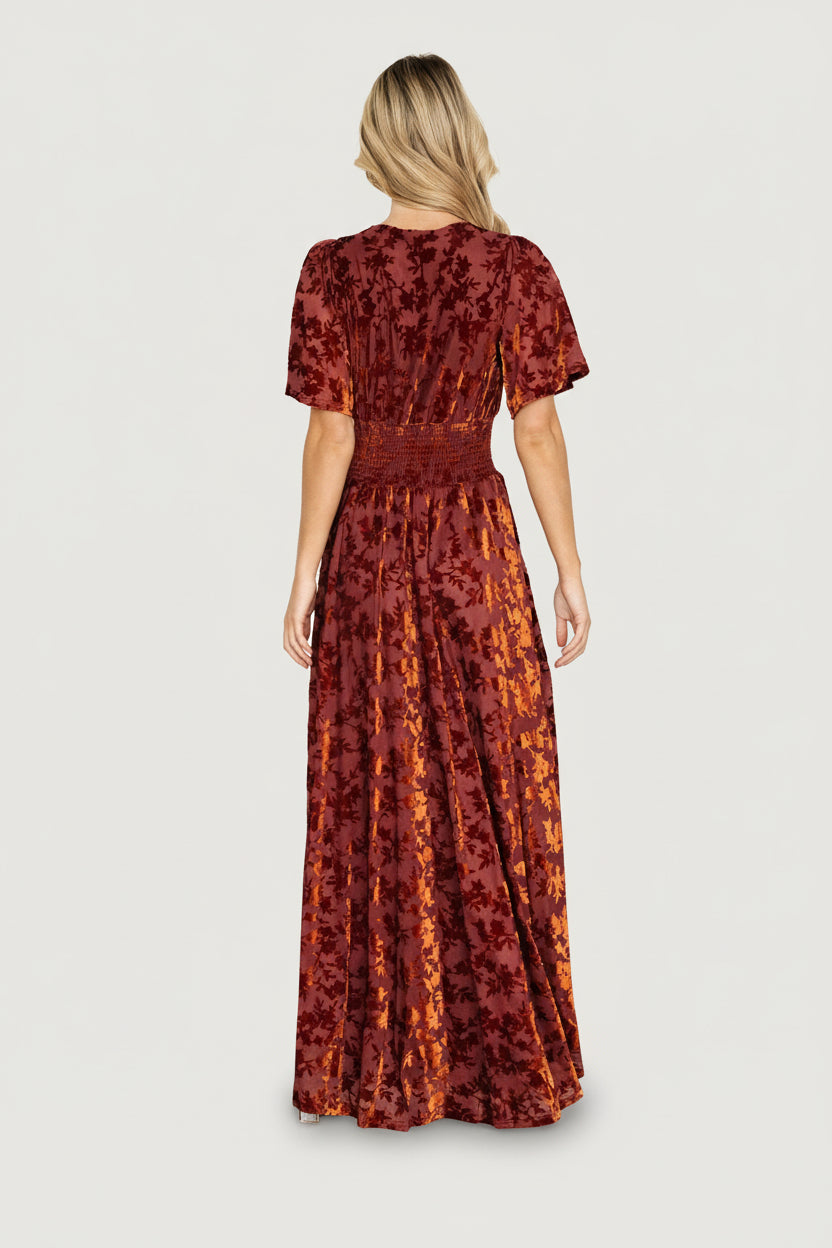 Studio front image of Veronica velvet maxi dress in rust, displaying V-neckline, smocked waist, and full lining.