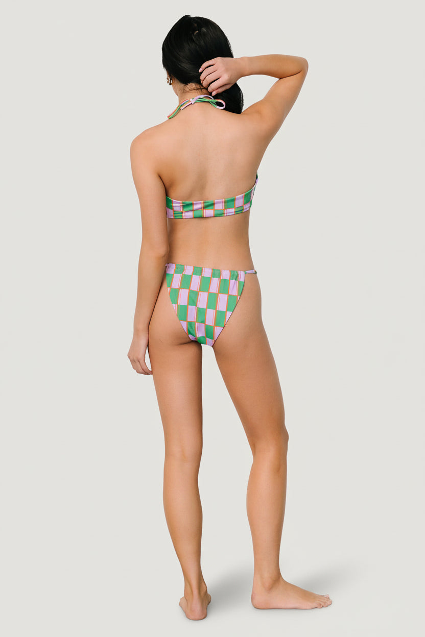 Side profile of adjustable bikini bottom showing tie detail and high-leg cut in lilac and green print.