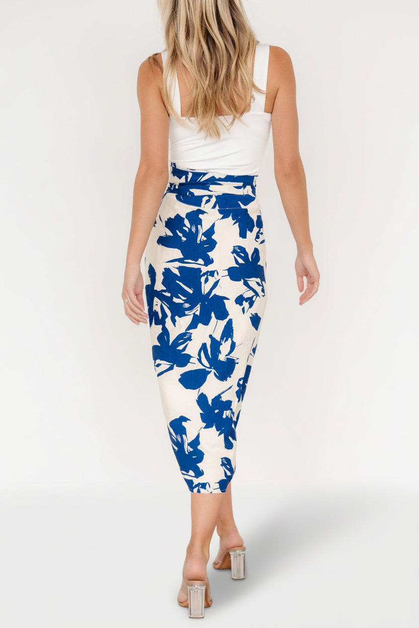 Side profile of the wrap midi skirt on a model, emphasizing the high-waisted fit, adjustable tie, and partial back lining at the rear.