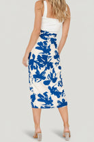 Model wearing the blue floral wrap midi skirt styled with a tucked top, showing movement and the skirt’s breathable, linen-like feel.