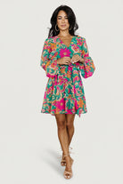 Front model view of Wesley Mini Dress in green multi floral print; lightweight chiffon, crossover V-neck, elastic waist and removable sash.