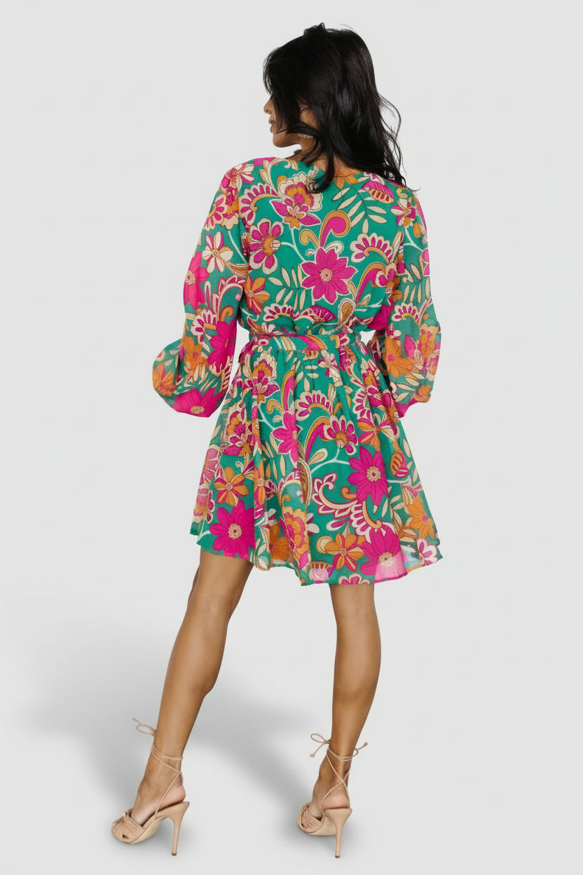Styled look of Wesley Mini Dress on model in green multi print, featuring chiffon sleeves, elastic waist with removable sash, and mini length.