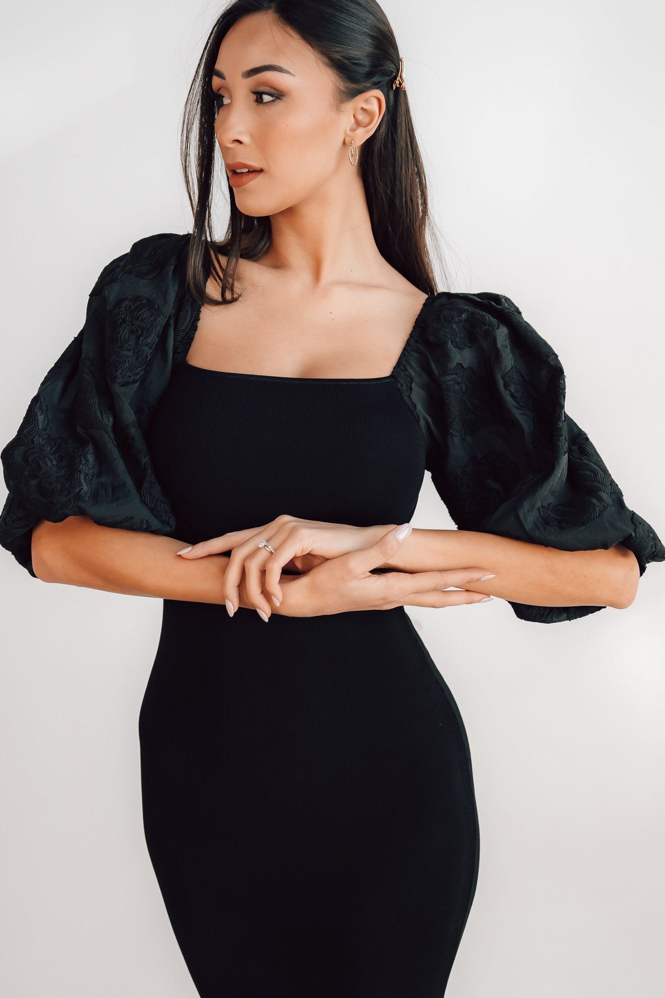 Full-length studio image of the black Weyland bodycon midi dress on model, showcasing overall silhouette, sleeve shape, and hem placement.