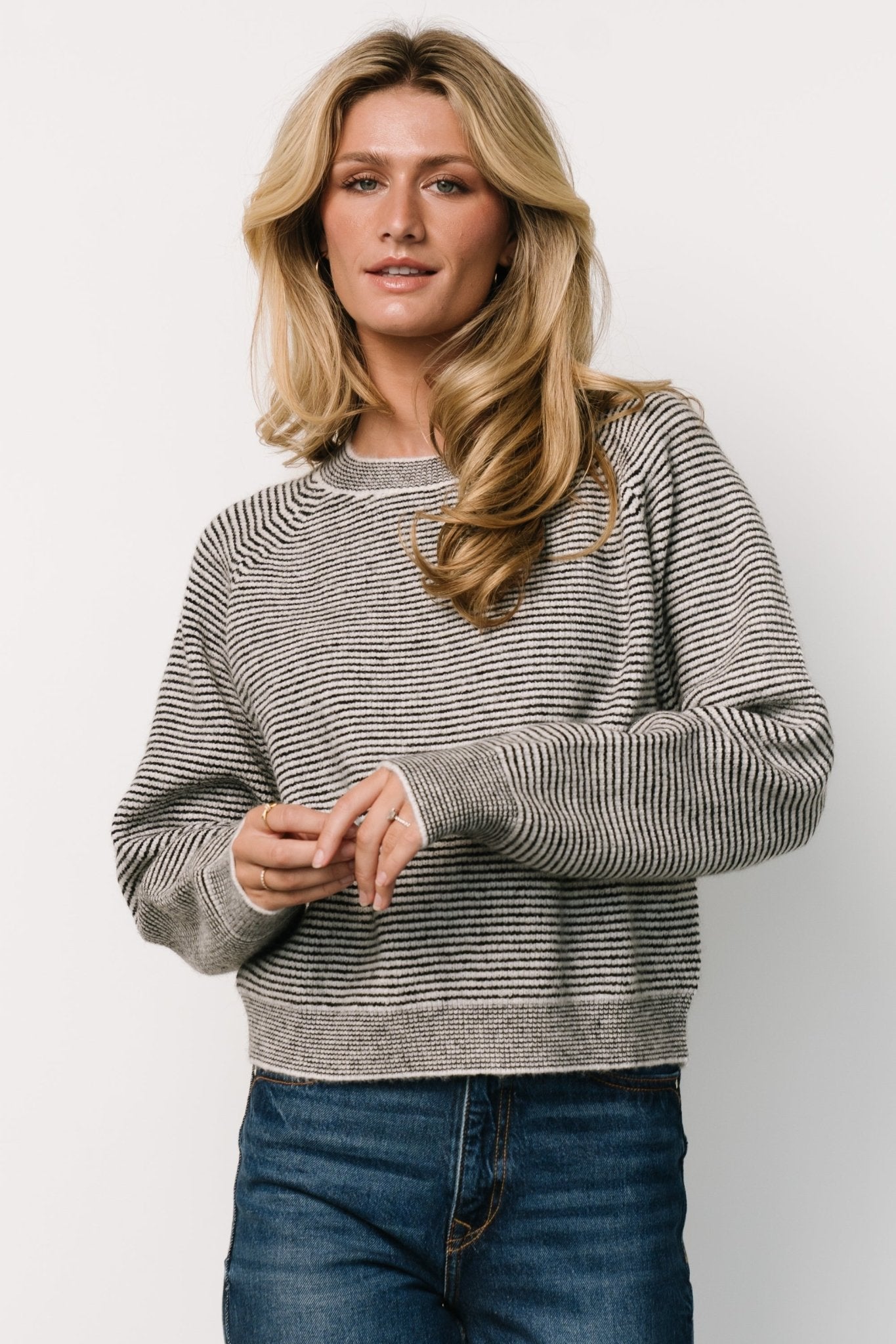 Front view of the Zadie Striped Sweater in ivory and black highlighting the high round neckline, raglan sleeves, and bold stripe pattern.