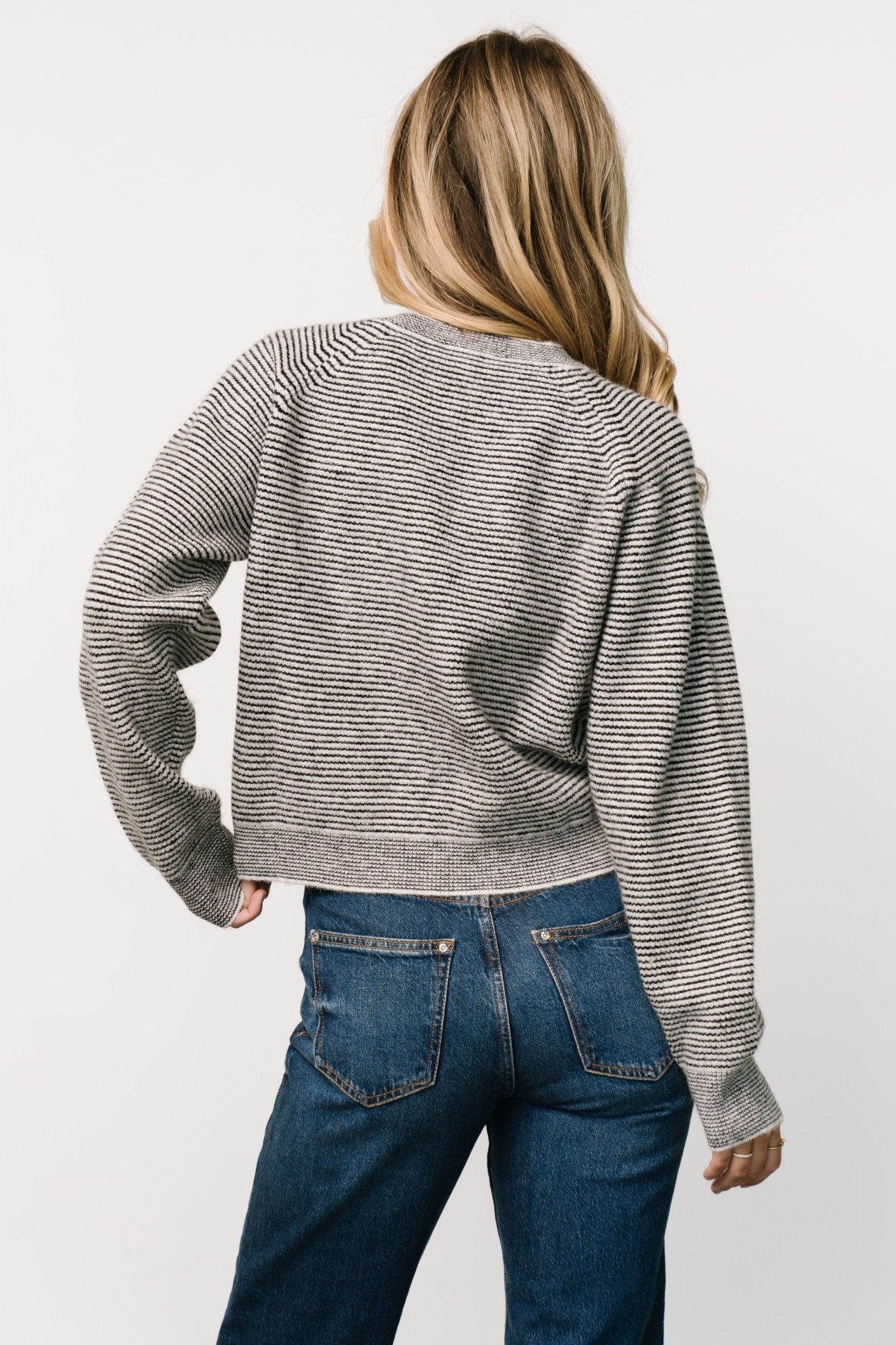 Back and side view of the Zadie Striped Sweater in ivory and black emphasizing raglan seam lines and how the stripes align across the back.