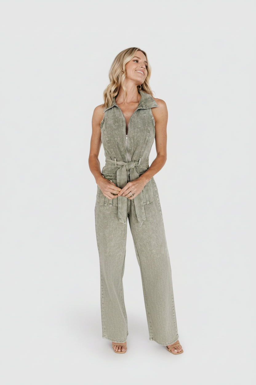 Detail shot of front patch pocket with button and topstitching on the cotton denim jumpsuit.