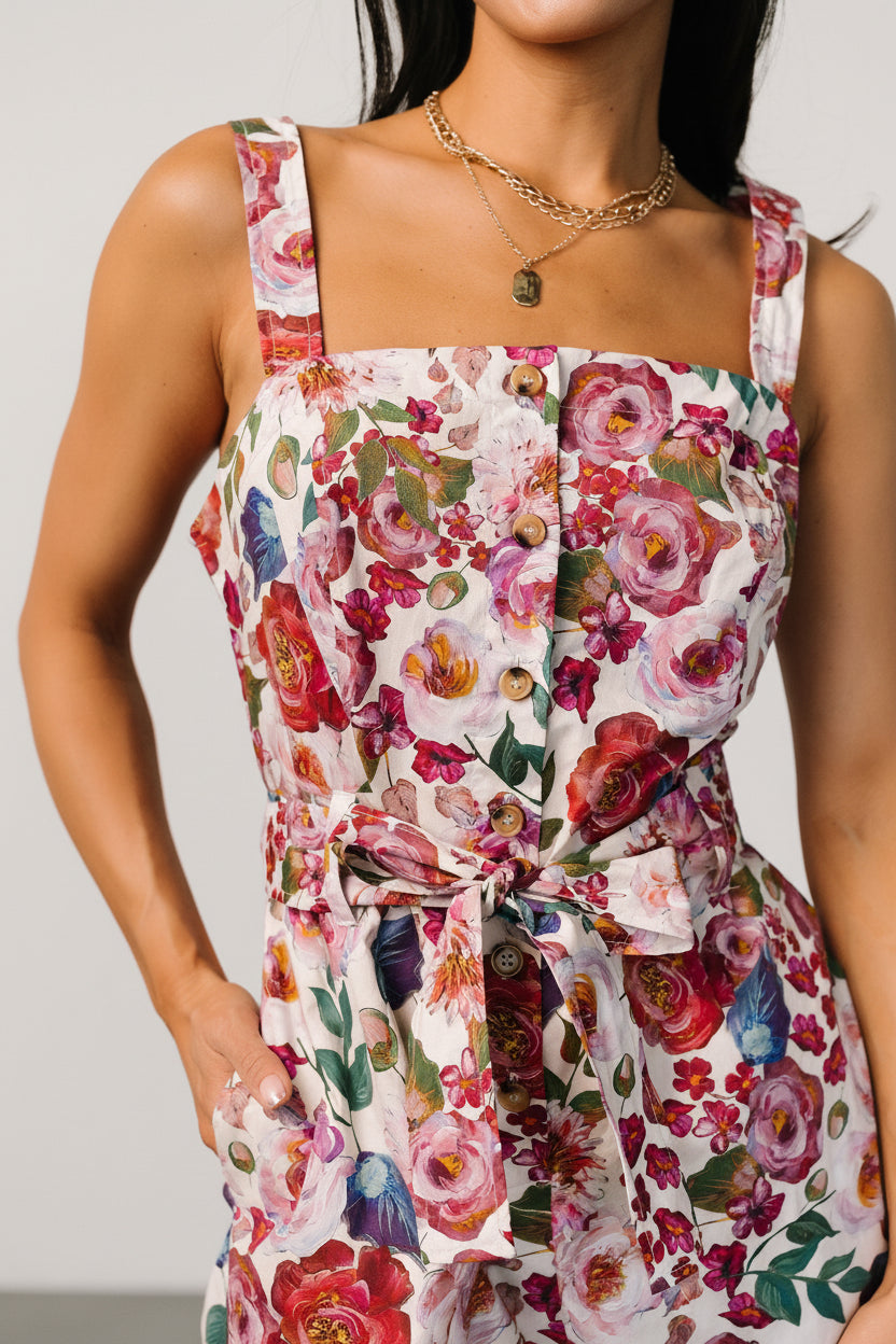 Flatlay of Zariah Romper showing full multi floral print, removable self-tie waist belt, and button-front details.