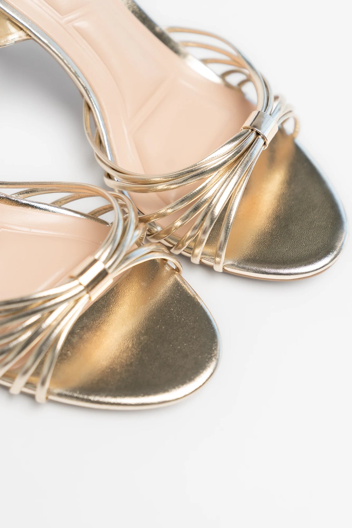 Zora Slim Flared Heel in Gold with delicate multi-strap design, open toe, adjustable ankle strap, and slim flared heel.