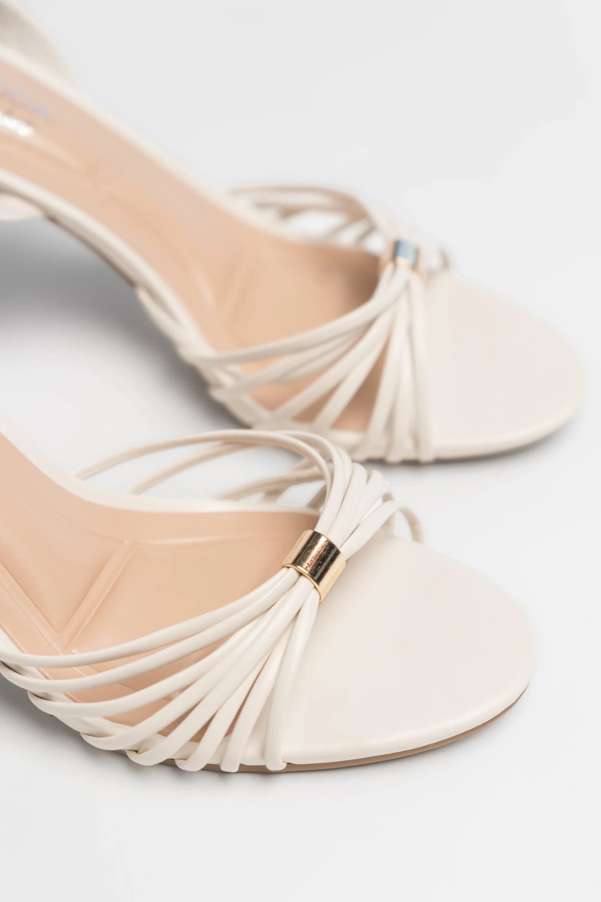 Zora Slim Flared Heel in Ivory with delicate multi-strap design, open toe, adjustable ankle strap, and slim flared heel.
