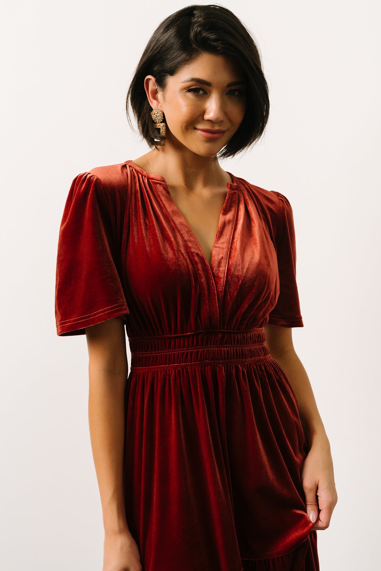 Detail view of short flutter sleeve and V-neckline on the Artemis terracotta velvet maxi dress showing feminine finishing.