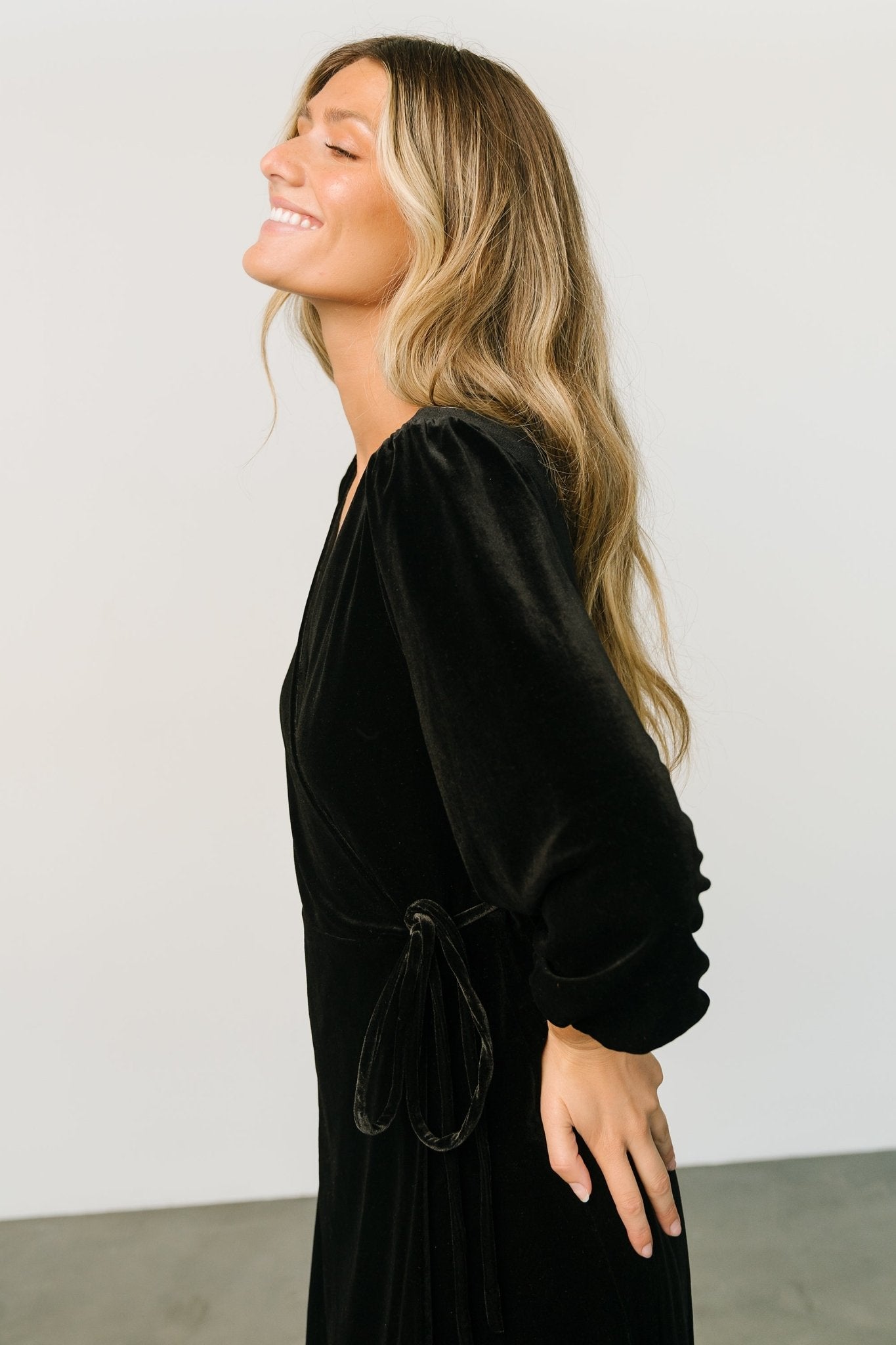 Detail image of the V-neck wrap front and seam finishing, with visible lining edge and cleanly stitched waist loop.