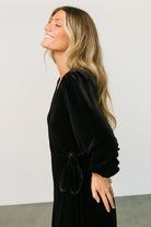 Detail image of the V-neck wrap front and seam finishing, with visible lining edge and cleanly stitched waist loop.