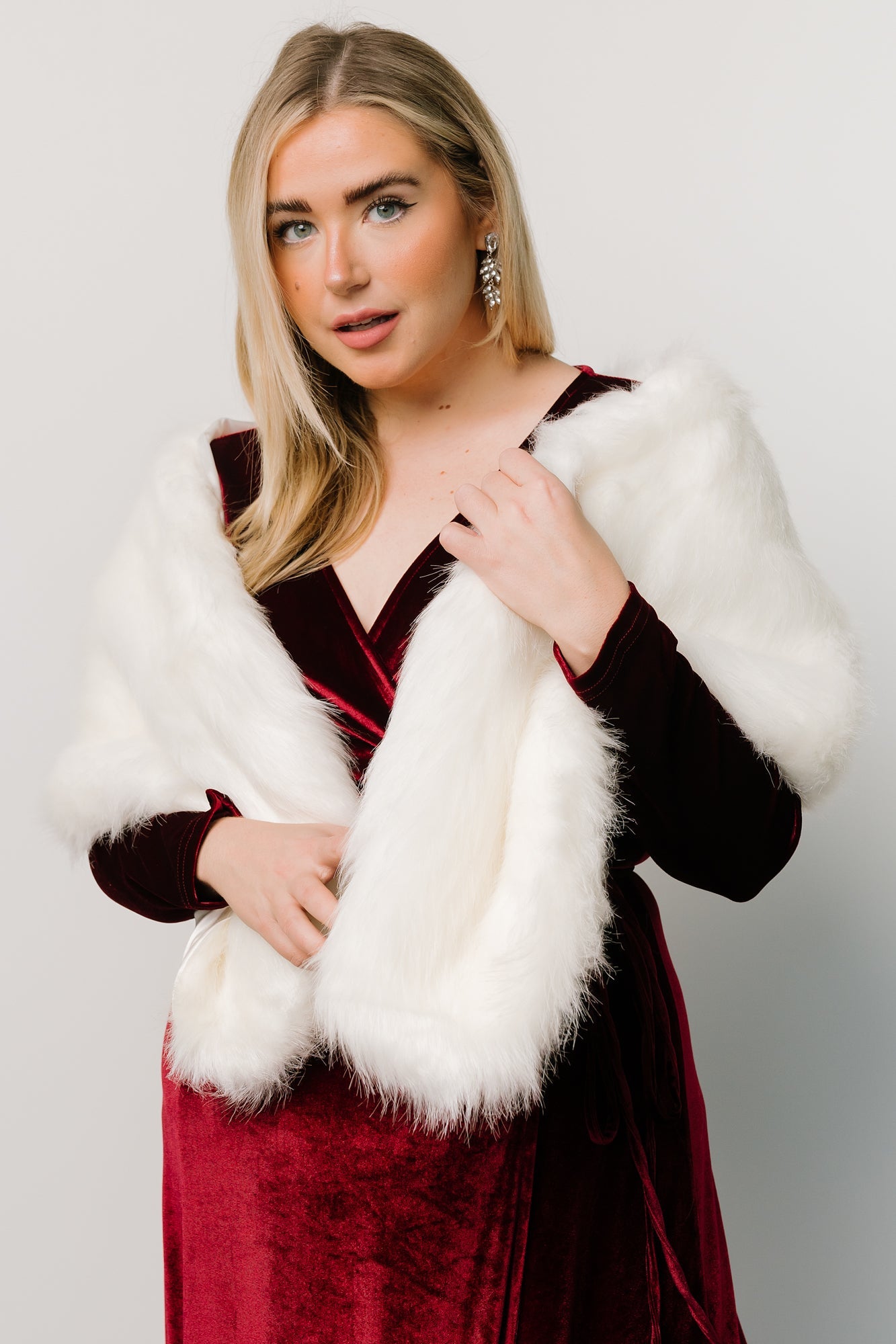 Full-length view of Pearl faux fur shawl worn as a stole, showing plush pile and subtle sheen of satin lining along hem.