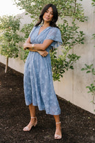 Styled outfit view of blue smocked midi dress paired with accessories, showcasing its versatility for both casual and formal occasions.