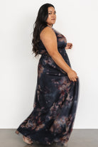 Back and side portrait of the dark blue floral tulle maxi dress showing the silhouette and gentle fullness of the skirt.
