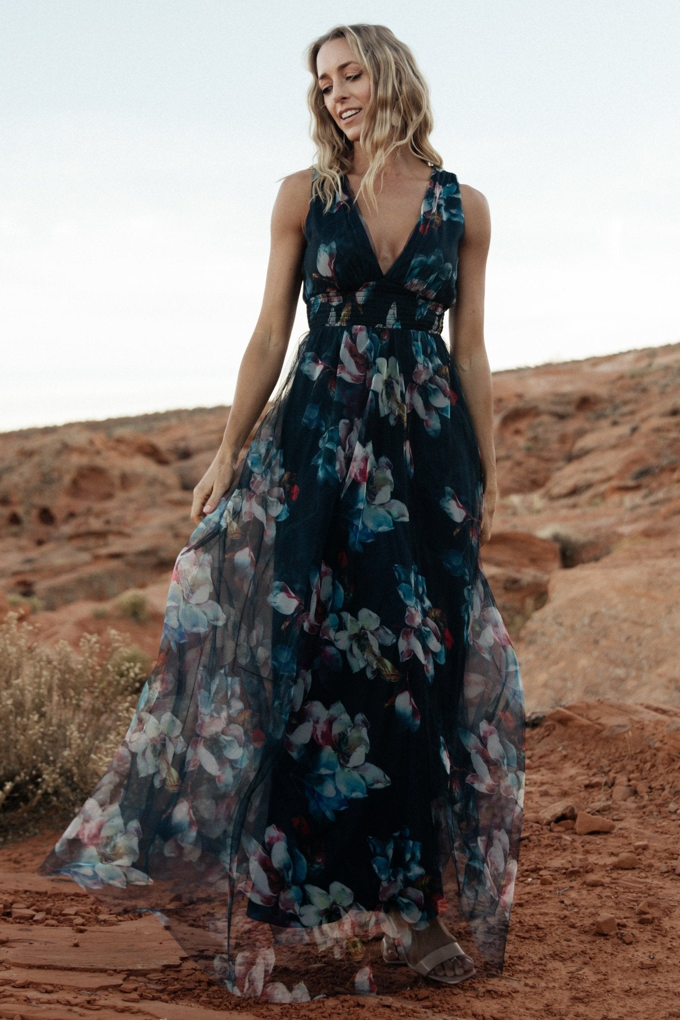 Detail image of the deep V-neckline and short tank sleeve on the navy abstract floral tulle maxi, highlighting neckline shaping.