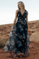Detail image of the deep V-neckline and short tank sleeve on the navy abstract floral tulle maxi, highlighting neckline shaping.