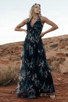 Full-length shot of model wearing the navy abstract floral tulle maxi dress paired with low heels to show length and overall silhouette.