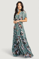 Full-length image of Katherine Maxi Dress in dusty green floral on model demonstrating length, tiered skirt panels, and lightweight chiffon silhouette.