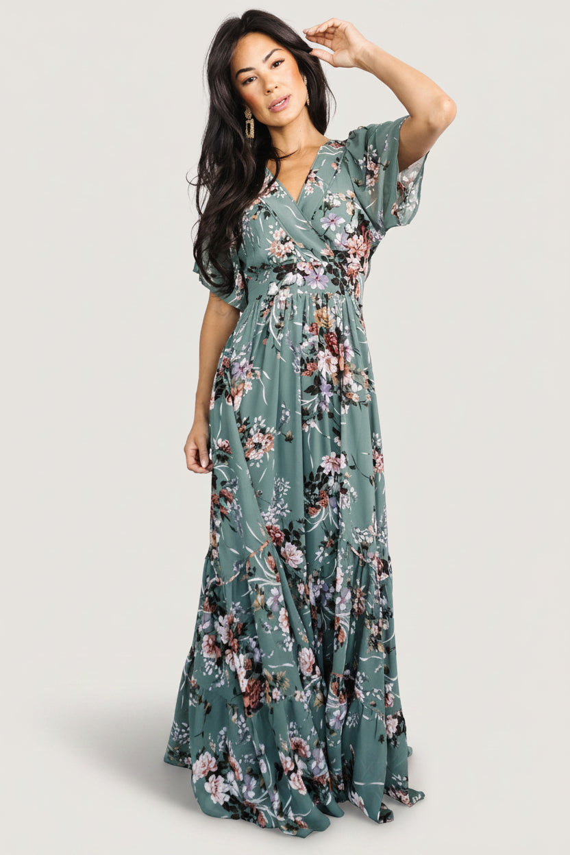 Model side view of Katherine Maxi Dress in dusty green floral highlighting angled tiered maxi skirt, soft drape, and natural movement of chiffon fabric.