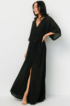Close-up of crossover surplice neckline and bodice of the Kia Kimono Maxi Dress in black showing fabric texture and seam details.