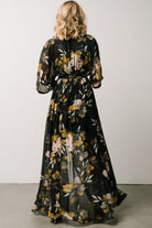 Back view of the black floral kimono maxi dress showing the flowing sleeve silhouette and full-coverage maxi skirt.