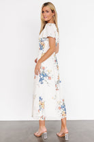 Styled look of the Kirsten Midi Dress in cream floral paired with neutral sandals, showing versatile daytime to evening wear potential.