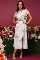 Front view of Kirsten Midi Dress in cream floral chiffon on model, showing smocked back waist and left leg slit for elegant movement.