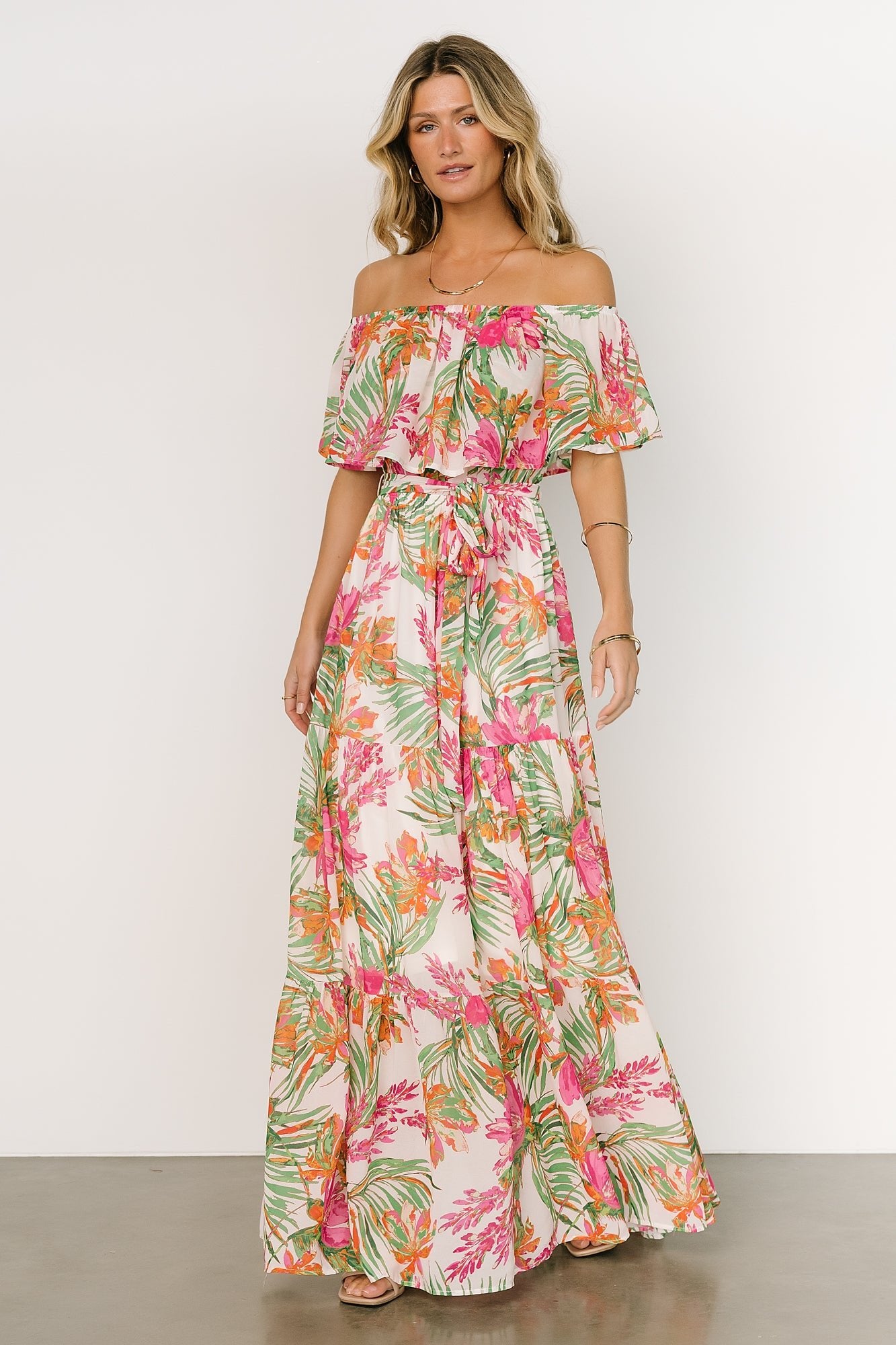 Back view of the Lahaina off-shoulder maxi dress on model, showing elastic neckline, tiered hem, and partial skirt lining.
