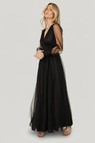 Back view of the black Layla Tulle Maxi Dress showing the flowing layered skirt, raw hem detail, and overall airy silhouette from behind.