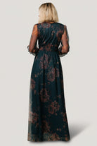 Back and side view of the copper and blue metallic tulle dress, showing raw hem, long tulle overlay, and elegant drape over the lined skirt.